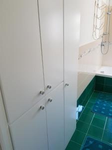 ein Badezimmer mit weißen Schränken und grünem Fliesenboden in der Unterkunft Villa Anna Rosa in Ravello