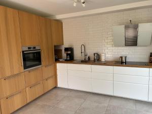 a kitchen with wooden cabinets and white appliances at Blaues Haus Plätlinsee in Wustrow