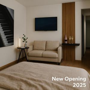 a living room with a couch and a television at VELUNA Salzburg One in Salzburg +6 photos