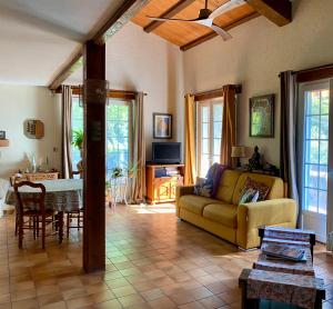 a living room with a couch and a table at Mas Pinède et Pierre in Saint-Julien-de-Peyrolas