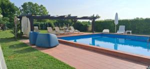 Casa MinolleにあるCasale Gelsomino primo pianoのスイミングプール(椅子、パーゴラ付)