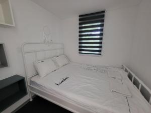 a white bed in a white room with a window at Mandrina House in Mandre