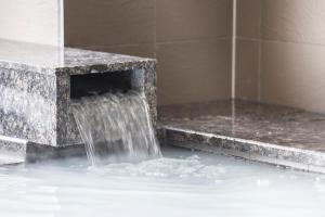 a fountain with water coming out of a stone bench at Hotel Vista Sendai in Sendai