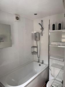 a white bathroom with a tub and a toilet at Corner Cottage in Derby +31 photos