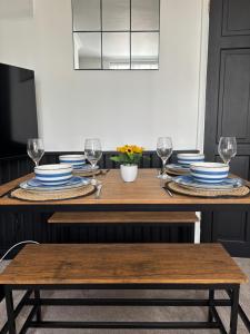 a dining room table with plates and wine glasses at Corner Cottage in Derby