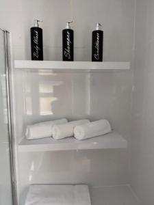 a refrigerator with three rolls of towels on shelves at Corner Cottage in Derby