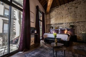 a bedroom with a bed and a balcony at Demeure Terrisse La Résidence in Marseillan