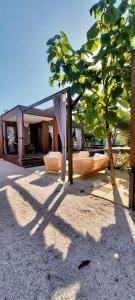 a pavilion with two beds and a tree at Stylish beach house in Privlaka in Privlaka