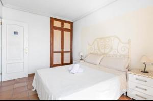 a white bedroom with a white bed and a window at Habitación Doble con Balcon in El Médano