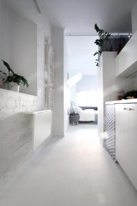 cocina con paredes blancas y suelo blanco en Bunga Apartament, en Varsovia