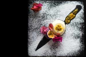 a dessert with a spoon and flowers on a table at Karongwe Portfolio - Kuname Lodge in Hoedspruit