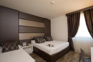 Ένα ή περισσότερα κρεβάτια σε δωμάτιο στο Toscana Ambassador