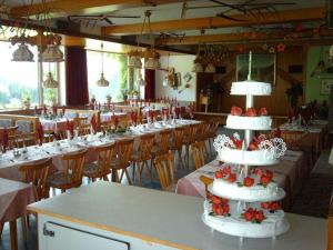 a large room with tables and chairs with a cake at Gasthof Mairwirt in Schwendt