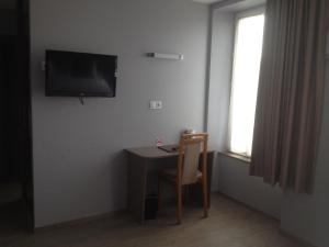 a living room with a tv and a desk at Hôtel de France in Isigny-sur-Mer