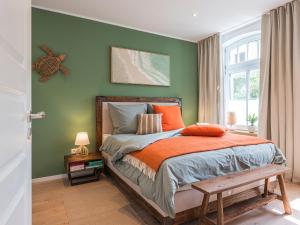 a bedroom with green walls and a bed with a bench at NEU Nature Retreat - Traumhafte Wohnung mit privater Sauna - 100m vom Strand in Rerik