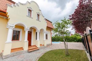 Casa blanca con puerta roja y patio en Golden Bridge Deluxe Home - 4BR, terrace, bar, privat pool, grill, en Balatonfüred