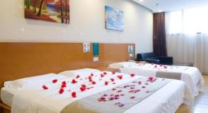 a room with two beds with red roses on them at GreenTree Inn LangFang YanJiao Tianyang Plaza Express Hotel in Gaolou