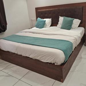 a bed with a wooden frame and pillows on it at Hotel White Rock Zirakpur in Zirakpur