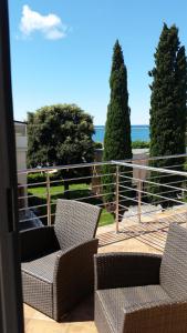 a balcony with two chairs and a view of the ocean at Apartments Villa Nona in Umag