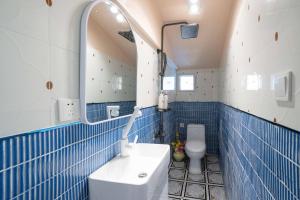 bagno piastrellato blu con lavandino e specchio di Xizhi B&B & Two-bedroom House a Shanghai Altre 29 foto