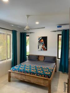 a bedroom with a bed with blue drapes at Sand Beach Boutique in Bwejuu