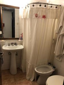 a bathroom with a shower curtain and a toilet and a sink at Departamento habitación doble equipado full in Cordoba +13 photos