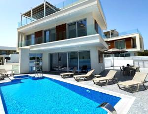 a house with a swimming pool in front of a house at Nissinest Luxury Villas in Ayia Napa