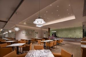 ein Restaurant mit Tischen und Stühlen in einem Raum in der Unterkunft Baichuan Business Hotel, Haizhu District, Guangzhou in Guangzhou
