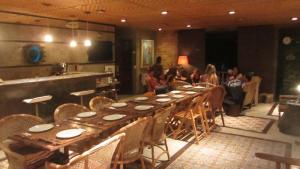 a long table in a restaurant with people sitting around it at Pousada Pilar in Arraial do Cabo