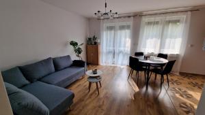 un soggiorno con un divano blu e un tavolo di Apartament z ogródkiem a Ciechocinek