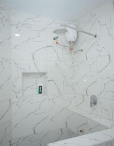 a bathroom with white marble walls and a shower at Clarah's paradise 2 in Mombasa