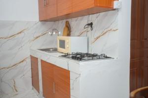 a kitchen with a stove and a microwave on a counter at Clarah's paradise 2 in Mombasa +3 photos