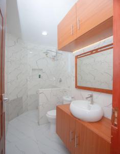 a white bathroom with a sink and a toilet at Clarah's paradise 2 in Mombasa