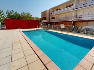 una piscina di fronte a un edificio di Appartement de charme avec piscine, terrasse, parking, clim et Wi-Fi – à 10 min des plages - FR-1-785-2 a Frontignan
