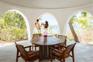una coppia in piedi in una stanza con un tavolo di Villa Kingdome - 2 Bedrooms a Teluknarat