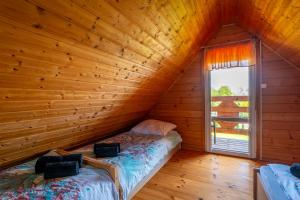 sypialnia w drewnianym domku z łóżkiem i oknem w obiekcie Domki Sielanka w mieście Niechorze +37 zdjęć