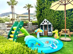 a playground with a slide and an umbrella at Bali Bay Luxury Apartment in Balíon