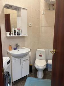 ein Badezimmer mit Toilette, Waschbecken und Spiegel in der Unterkunft Monro-style in the historical center in Odessa