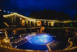 a woman sitting in a hot tub at night at Baldones dabas retrīts - Exclusive holiday house near Riga jacuzzi sauna extra cost in Pulkarne
