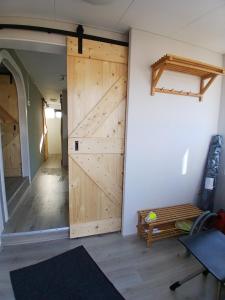 a room with a sliding barn door and a bench at Ruim en rustig chalet in Nationaal park de Drentsche Aa max 5 prs in Anloo