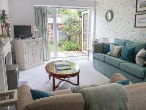 a living room with a blue couch and a table at 1 Coconut Cottage, Long Melford in Long Melford