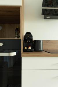 a kitchen with a counter with a microwave and a stove at L'Echapée Belle en Val de Saône in Saint-Didier-sur-Chalaronne