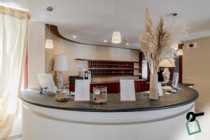 a lobby with a round table with glasses and flowers at HOTIDAY Room Collection - Mattinata Faraglioni in Mattinata