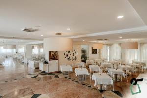 a banquet hall with white tables and white chairs at HOTIDAY Room Collection - Mattinata Faraglioni in Mattinata