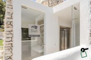 a window in a white house with a mirror at HOTIDAY Room Collection - Mattinata Faraglioni in Mattinata