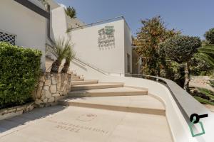 a set of stairs leading up to a white building at HOTIDAY Room Collection - Mattinata Faraglioni in Mattinata