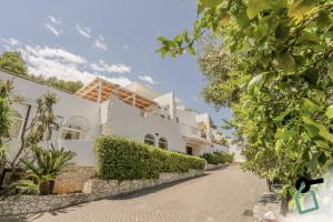 a large white house with a driveway at HOTIDAY Room Collection - Mattinata Faraglioni in Mattinata
