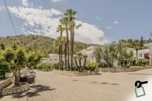 a street with palm trees and buildings in the background at HOTIDAY Room Collection - Mattinata Faraglioni in Mattinata