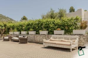 a row of chairs and couches sitting next to a stone wall at HOTIDAY Room Collection - Mattinata Faraglioni in Mattinata