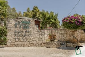 a stone wall with a potted plant on it at HOTIDAY Room Collection - Mattinata Faraglioni in Mattinata